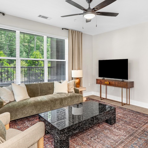 a living room with a couch, chair, tv and coffee table