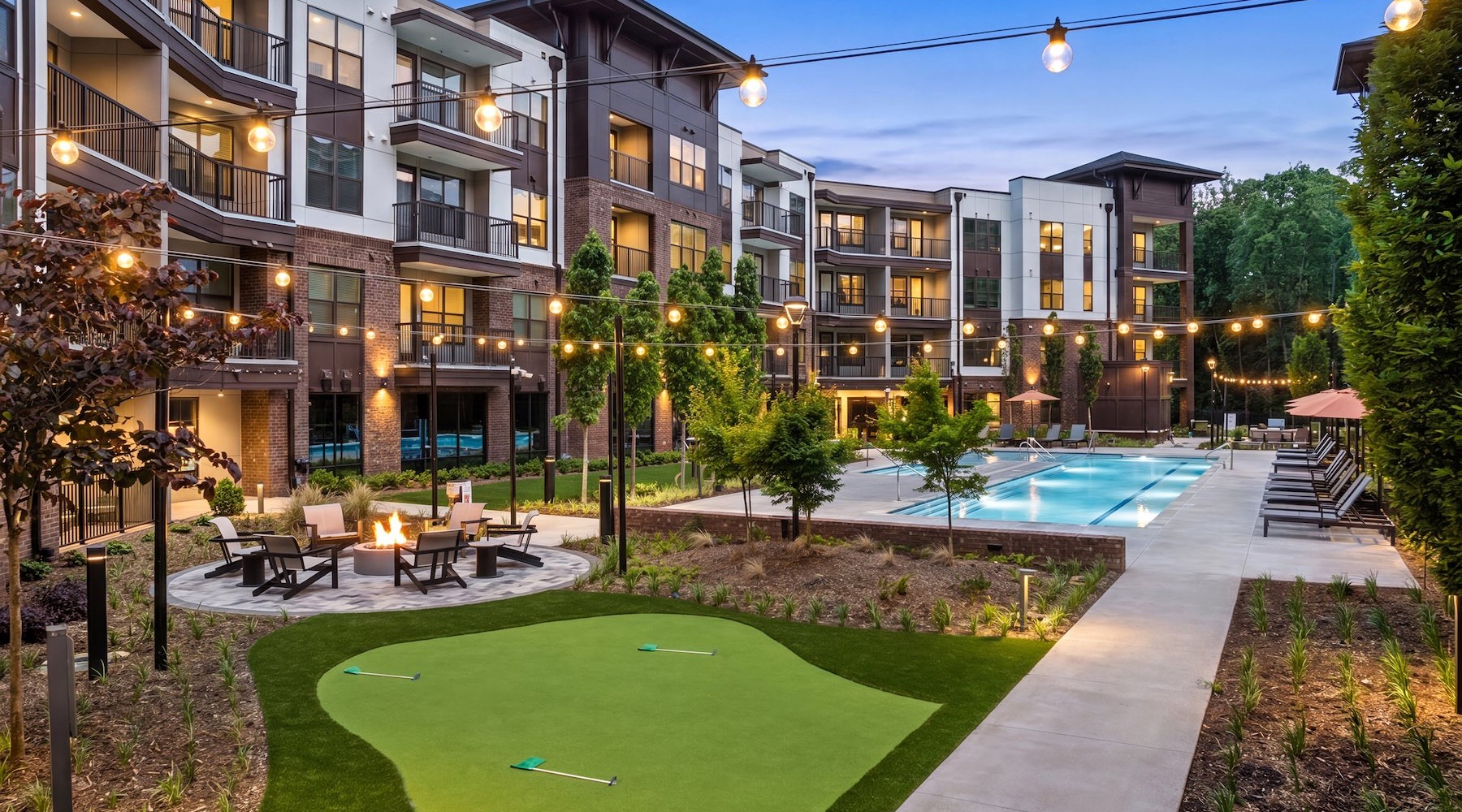 a courtyard with a pool, fire pit and putting green