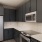 Model kitchen at Weller at the Preserve senior apartments in Asheville, featuring tiled backsplash and grey cabinetry.