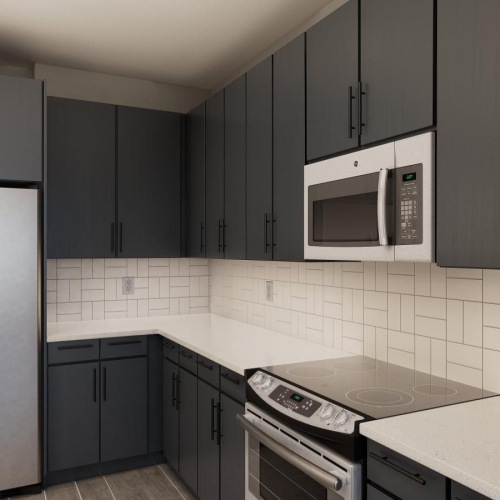 Settle into comfort at Weller at the Preserve Model kitchen at Weller at the Preserve senior apartments in Asheville, featuring tiled backsplash and grey cabinetry.